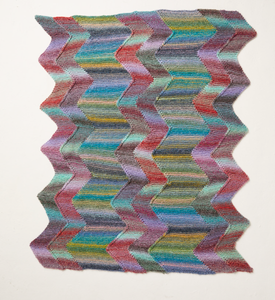 Multicoloured Sirdar 10708 Jewelspun Chunky zigzag patterned knitted blanket on a white background