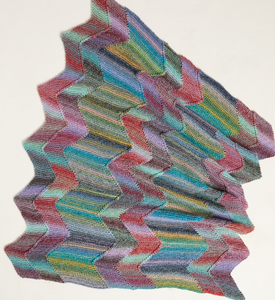 Multicoloured zigzag patterned knitted blanket on a white background