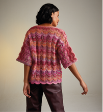 Load image into Gallery viewer, Woman wearing a colourful Sirdar 10715 Jewelspun knitted cardigan against a neutral background