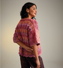 Load image into Gallery viewer, Woman wearing a colourful knitted Sirdar 10715 Jewelspun lace knit cardigan against a plain background