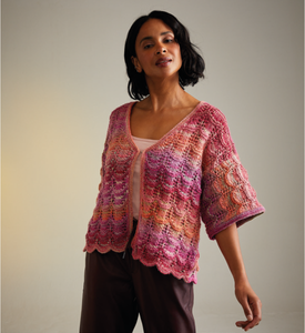 Woman wearing a colourful knitted cardigan against a plain background